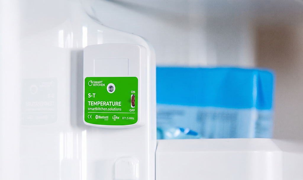 SmartKitchen S-T temperature measuring device mounted on the inside wall of a refrigerator.
